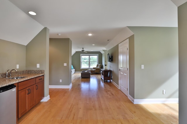 kitchen featuring dishwasher, sink, ceiling fan, light stone countertops, and light hardwood / wood-style floors