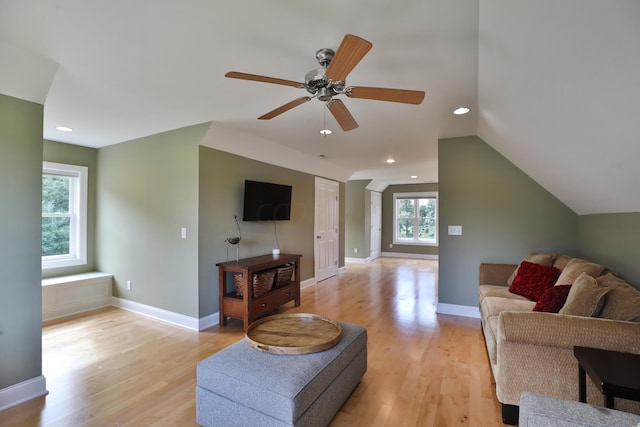 living room with light hardwood / wood-style floors, vaulted ceiling, and ceiling fan