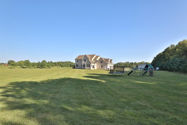 view of yard with a playground and a trampoline