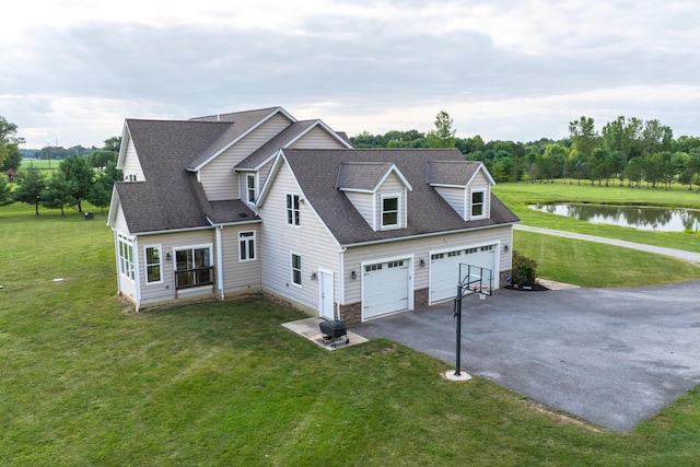 view of front facade featuring a garage, a water view, and a front lawn