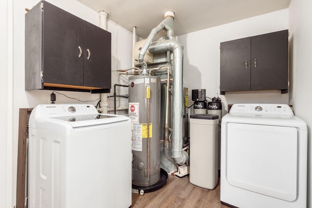 laundry area featuring cabinets, independent washer and dryer, light wood-type flooring, and water heater