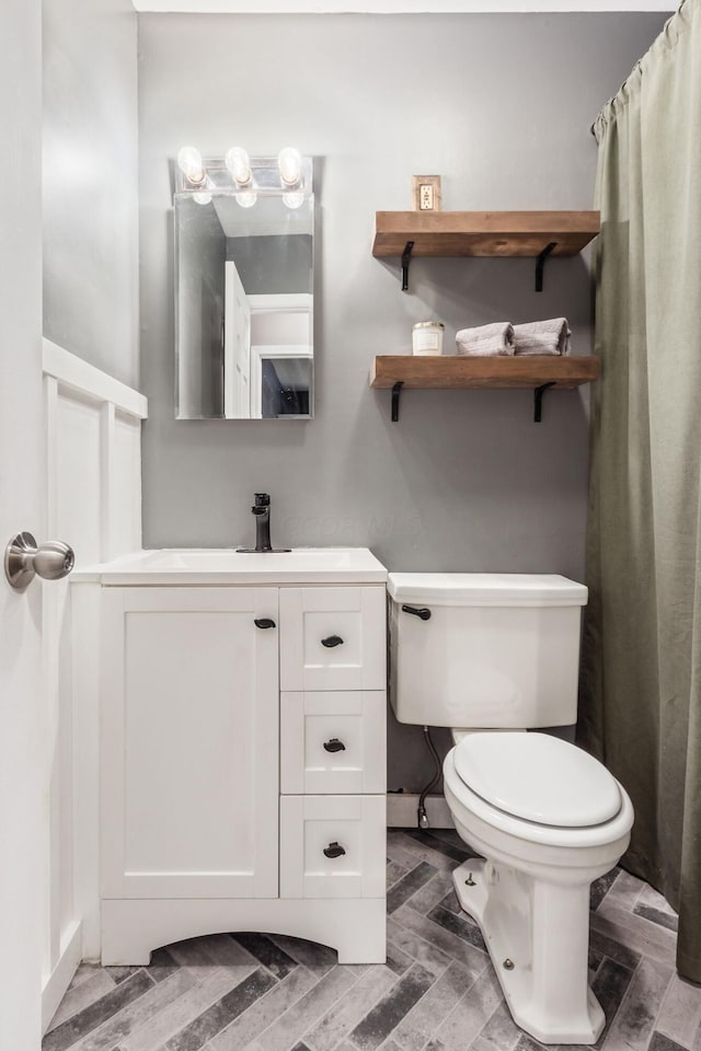 bathroom with vanity, wood-type flooring, and toilet