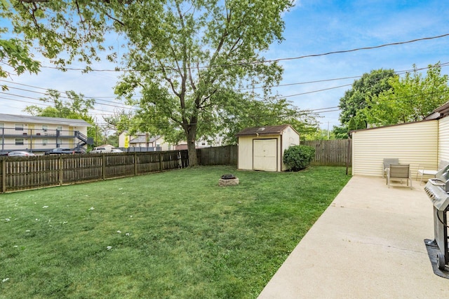 view of yard featuring a storage unit and an outdoor fire pit