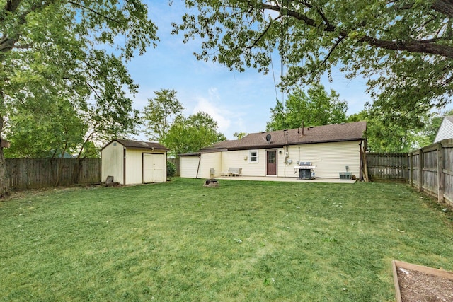 back of house with a yard, a patio area, and a storage shed