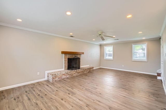 unfurnished living room with ornamental molding, recessed lighting, a ceiling fan, wood finished floors, and a brick fireplace