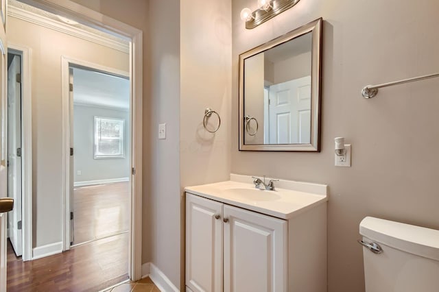half bath with vanity, toilet, and baseboards