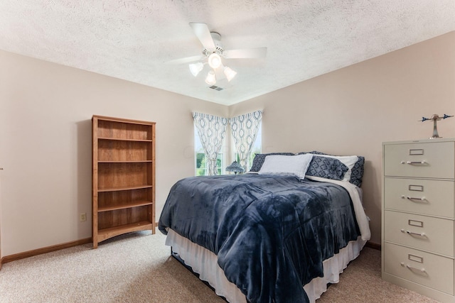 bedroom featuring ceiling fan, light carpet, and a textured ceiling