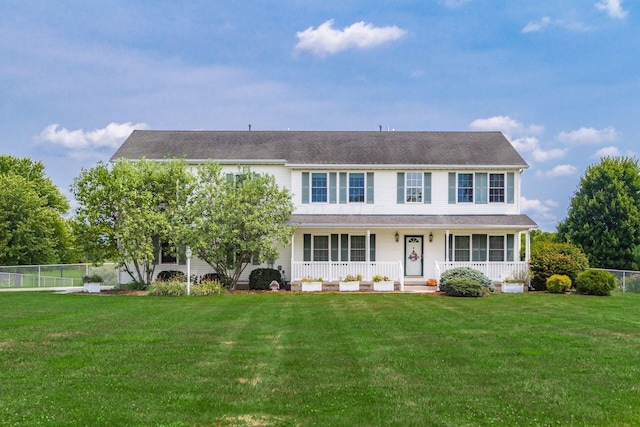 colonial home featuring covered porch and a front yard