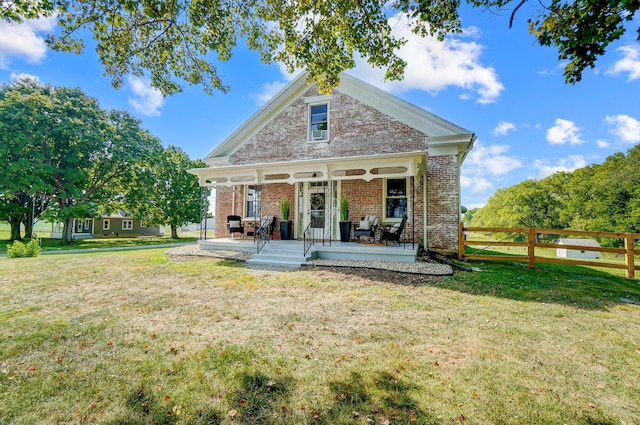 back of property featuring covered porch and a lawn