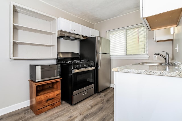 1328 Kent St, Columbus, OH 43205 - kitchen featuring stainless steel appliances, under cabinet range hood, open shelves, light wood-style flooring, and white cabinets