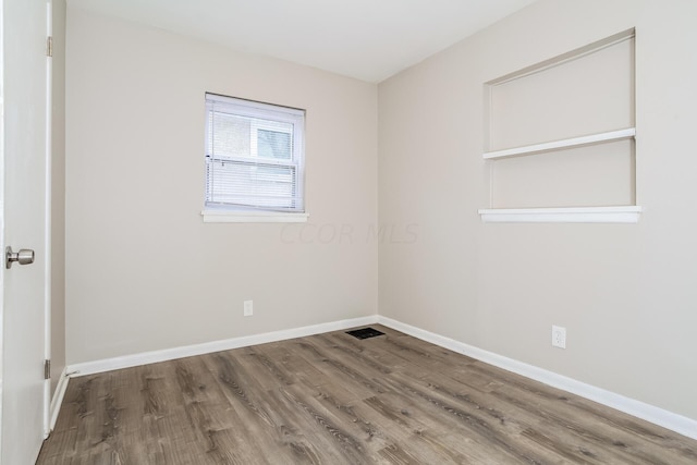 unfurnished room featuring hardwood / wood-style flooring