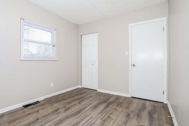 unfurnished bedroom with dark hardwood / wood-style flooring