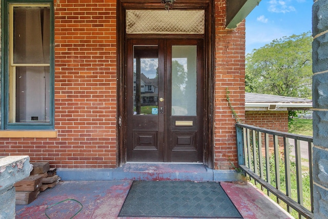 view of exterior entry featuring covered porch and french doors