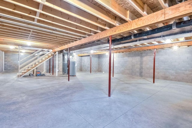 unfinished below grade area featuring water heater and stairway