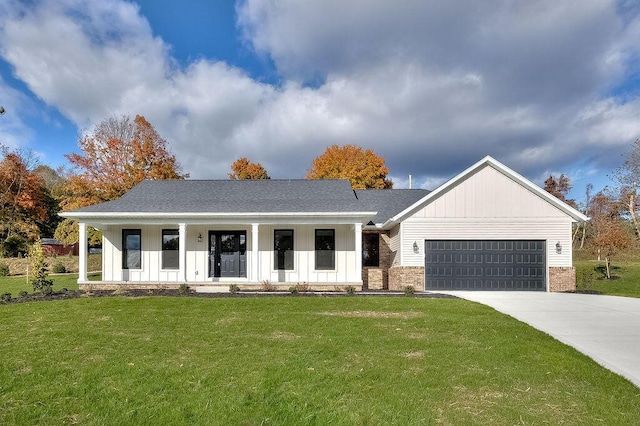 view of front of property featuring a porch, a front lawn, and a garage