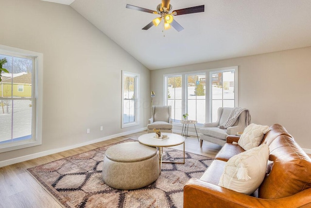 living area with high vaulted ceiling, ceiling fan, baseboards, and wood finished floors