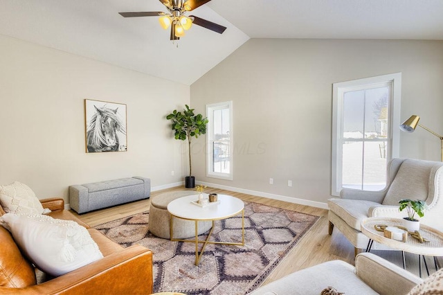 living area featuring vaulted ceiling, ceiling fan, wood finished floors, and baseboards