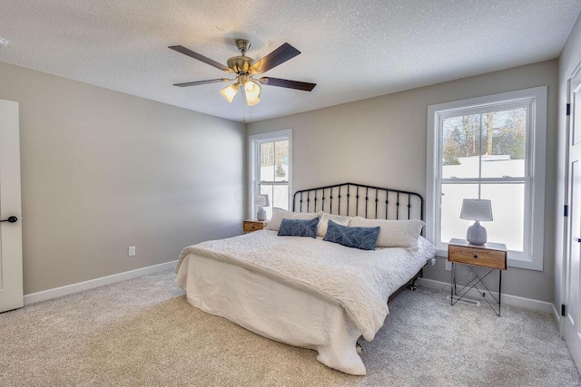 bedroom with ceiling fan, a textured ceiling, and carpet flooring