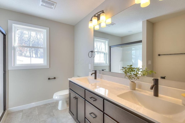 bathroom with an enclosed shower, visible vents, and a sink