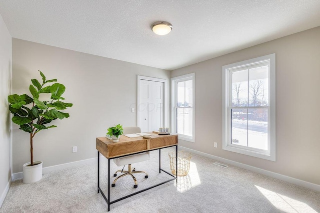 carpeted office space featuring visible vents, a textured ceiling, and baseboards