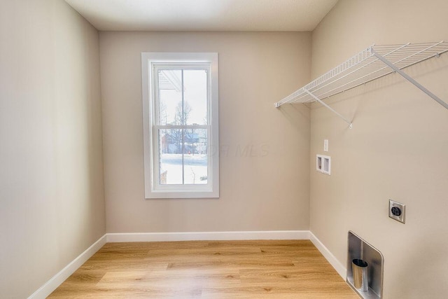 washroom featuring light wood-type flooring, laundry area, hookup for an electric dryer, and baseboards