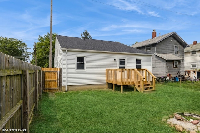 back of property featuring a yard and a deck