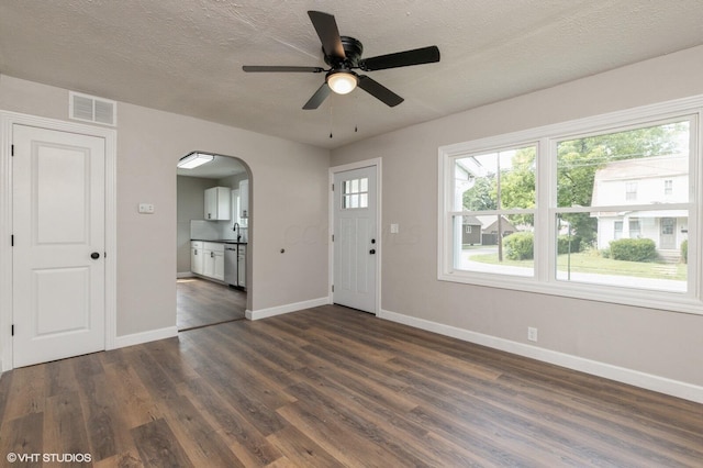 foyer with a textured ceiling, dark hardwood / wood-style floors, and ceiling fan