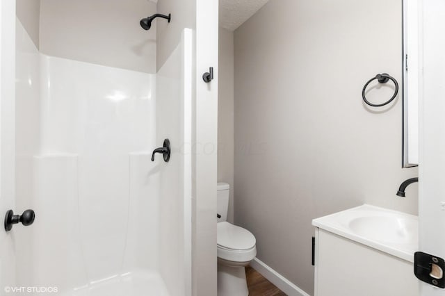 bathroom featuring a textured ceiling, vanity, a shower, wood-type flooring, and toilet