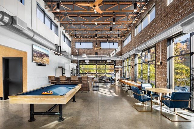 playroom with concrete floors, pool table, and a towering ceiling