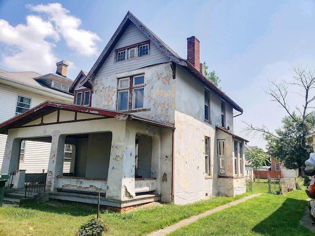 back of property with a porch and a yard