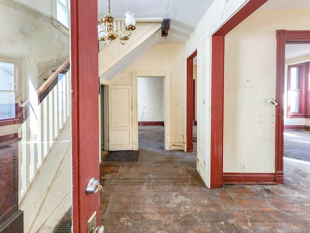 corridor with a notable chandelier and vaulted ceiling