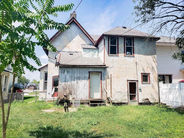 rear view of house featuring a yard