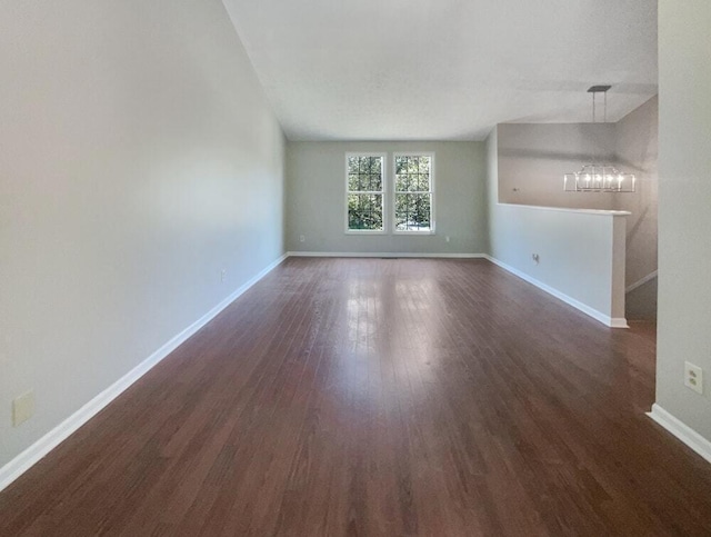 unfurnished room featuring dark hardwood / wood-style flooring and a notable chandelier