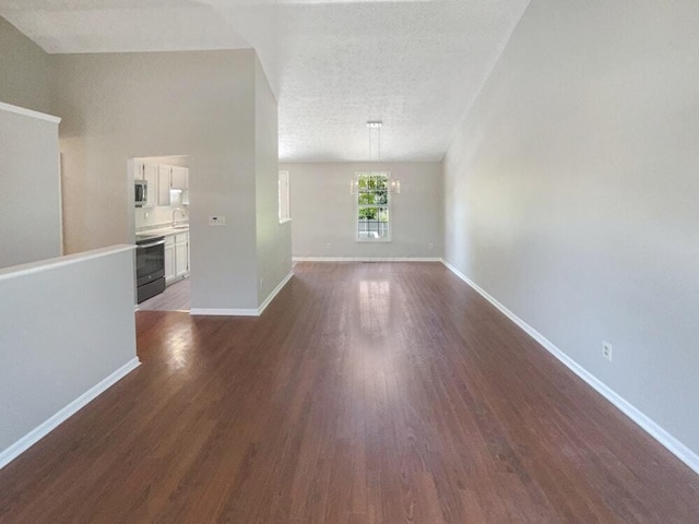 unfurnished living room with a textured ceiling, sink, a chandelier, and dark hardwood / wood-style floors