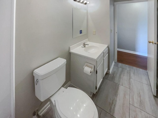 bathroom with hardwood / wood-style floors, vanity, and toilet