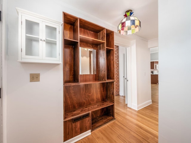 mudroom with light wood-type flooring and crown molding