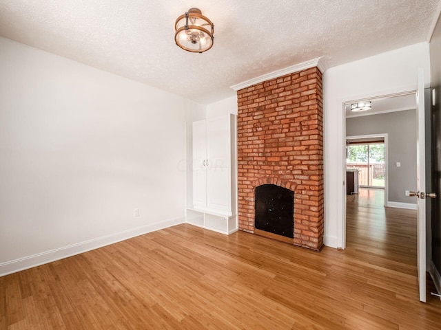 unfurnished living room with a fireplace, wood-type flooring, and a textured ceiling