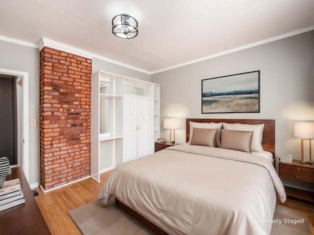 bedroom featuring crown molding and light hardwood / wood-style flooring