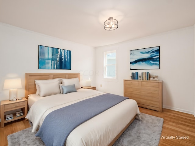 bedroom featuring light wood-type flooring and ornamental molding