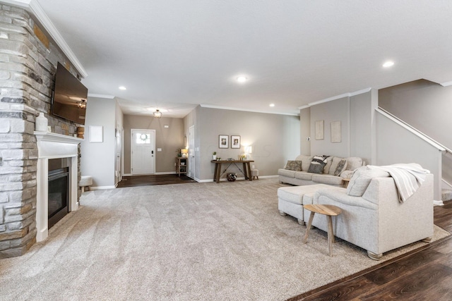 living room featuring wood-type flooring, ornamental molding, and a fireplace