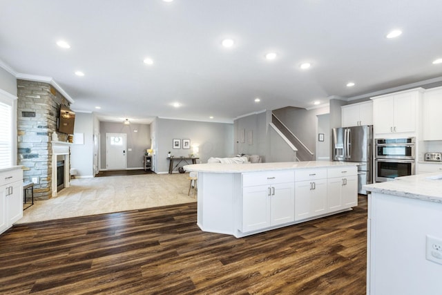 kitchen with crown molding, dark hardwood / wood-style flooring, white cabinets, and appliances with stainless steel finishes