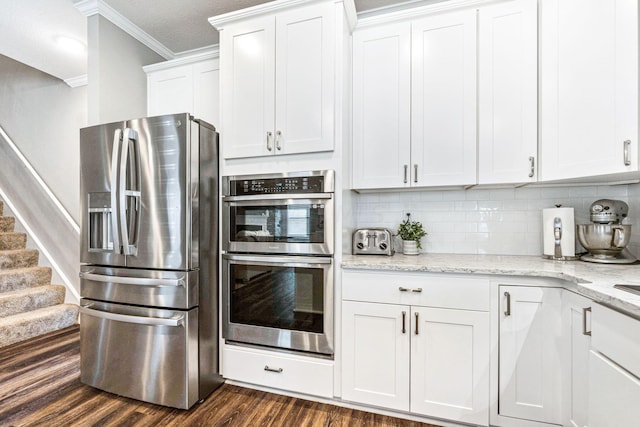 kitchen featuring light stone countertops, white cabinetry, stainless steel appliances, dark hardwood / wood-style floors, and crown molding