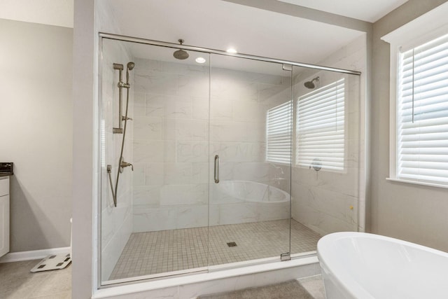 bathroom featuring plus walk in shower, tile patterned floors, and a wealth of natural light