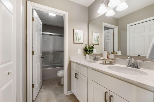 full bathroom featuring tile patterned floors, vanity, enclosed tub / shower combo, and toilet