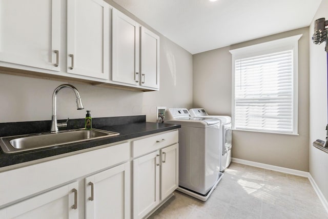 laundry room with cabinets, light tile patterned floors, sink, and washing machine and clothes dryer