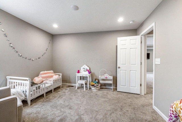 carpeted bedroom featuring a crib