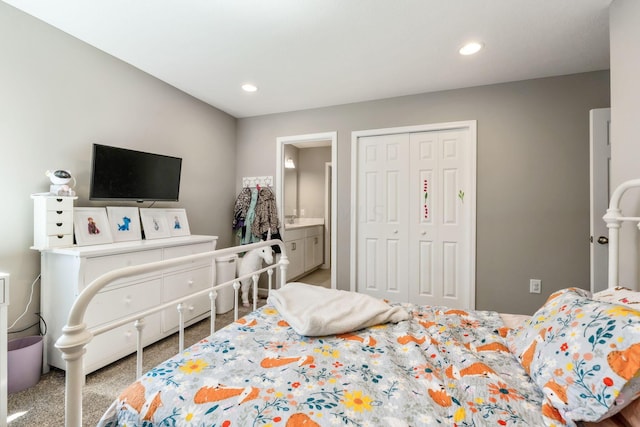 bedroom featuring light carpet, a closet, and ensuite bathroom