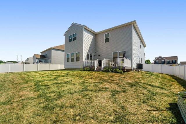 back of house featuring central air condition unit, a lawn, and a wooden deck