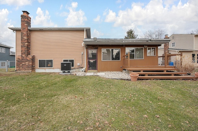 rear view of property featuring a wooden deck, cooling unit, and a lawn