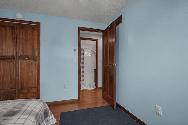 bedroom with a closet, wood-type flooring, and a textured ceiling